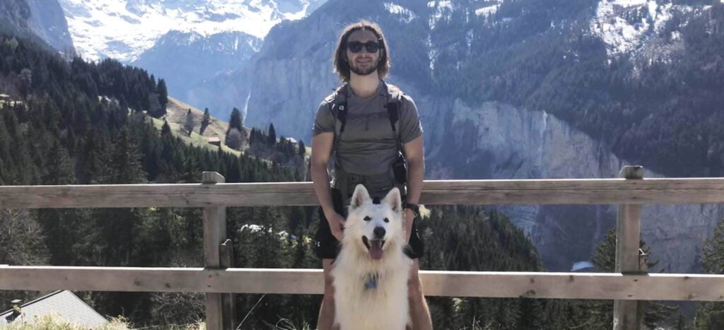 The Chef Tomy et un chien, devant un paysage montagneux en été