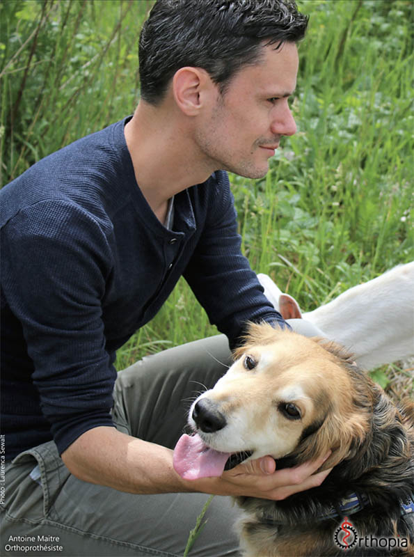 Antoine Maitre avec un chien, dans une prairie